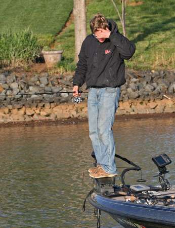 <p>
	Mark Condron uses his trolling motor bracket to rise a few more inches above the water to look for bedding bass on Friday morning.</p>
