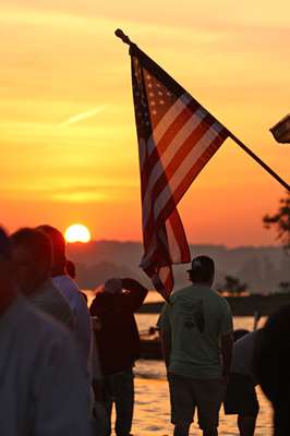 <p>
	The sun rises behind the American flag on Day One at Lake Dandridge.</p>
