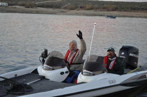 <p>
	Andy Bravence, current leader of the Arizona team, waves to another boater while Frank Villa, Colorado, looks on.</p>
