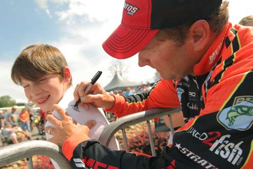 <p>
	Mike McClelland signs an autograph for a young happy fan.</p>
