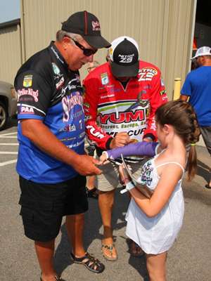 <p>
	Denny Brauer and Matt Reed autograph a young girls cast.</p>
