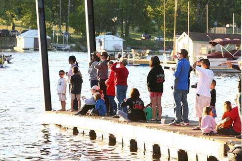 <p>
	Family and friends snap photos and cheer on the anglers as they pass the floating dock.</p>
