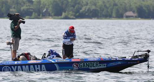 <p>
	Dean Rojas, in second place after Day One, adjusts his lure.</p>

