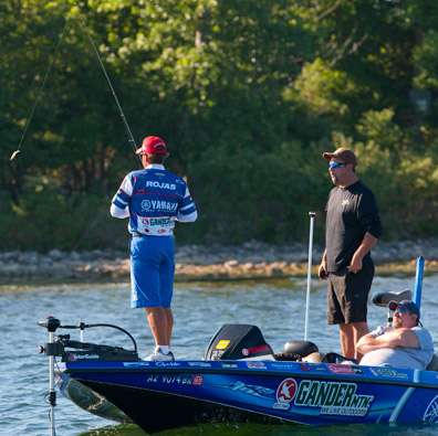 <p>
	Mark Zona looks on as Rojas inspects his bait. Rojas is the Day Two leader with 37-12.</p>
