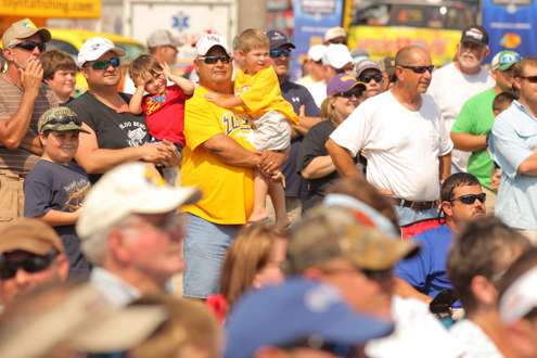 <p>
	Fans crowd around to watch anglers bring their bass to the stage.</p>
