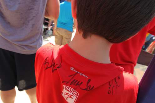 <p>
	A young fan collects autographs on his t-shirt.</p>
