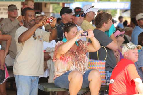 <p>
	Fans take photos of the anglers as they proceed through the weigh-in line in their boats.</p>
