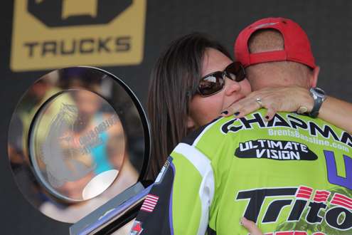 <p>
	Chapman receives a hug from wife Bobbi after claiming the champion's trophy.</p>
