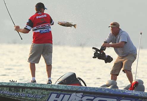 <p>
	Pace jerks a keeper into the boat while Rick Mason captures video for Bassmaster television. </p>
