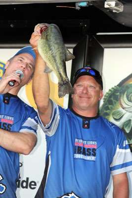 <p>
	Tourney contestant Tim Vanderhill of Kalamazoo shows off the 5-pound bass that he caught as the big bass winner of the tournament.</p>
