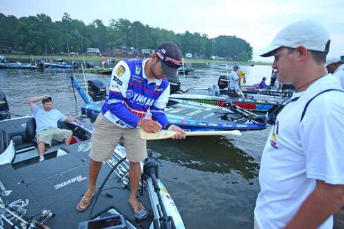 <p>
	Brandon Palaniuk initials a paddle for a lucky spectator.</p>

