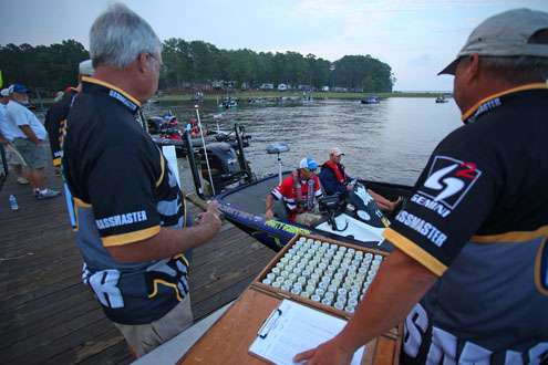 <p>
	B.A.S.S. officials pass out boat numbers as they go by the boat check dock.</p>

