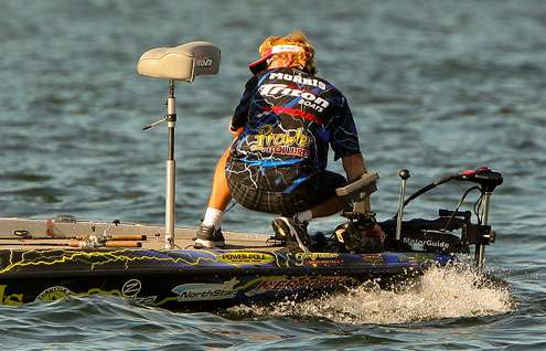 <p>
	Rick Morris kneels and uses his trolling motor to drag a fish to deeper water.</p>

