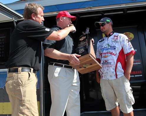 <p>
	A Bass Pro Shops rep hands the trophy over to the 23-year-old from DeWitt, Va.</p>
