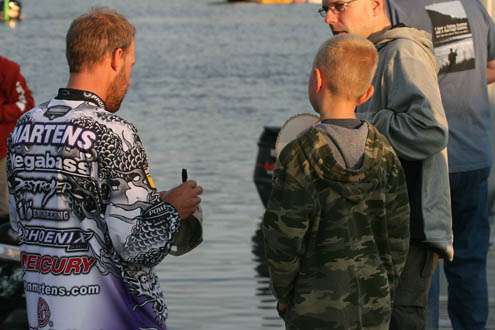 <p>
	Day One leader Aaron Martens happily signs an autograph for a father and son at the boat ramp.</p>
