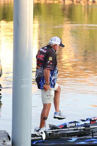 <p>
	Tommy Biffle takes a step aboard his boat on a calm Sunday morning.</p>

