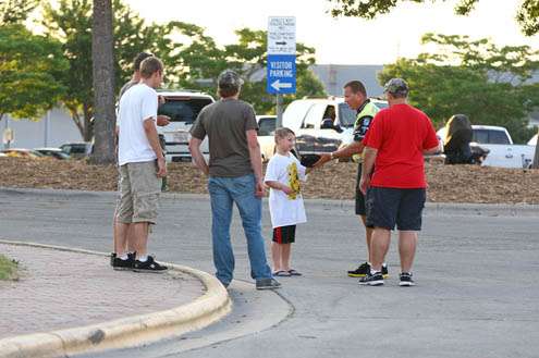 <p>
	Skeet Reese stops in the parking lot to sign an autograph for a young fan.</p>

