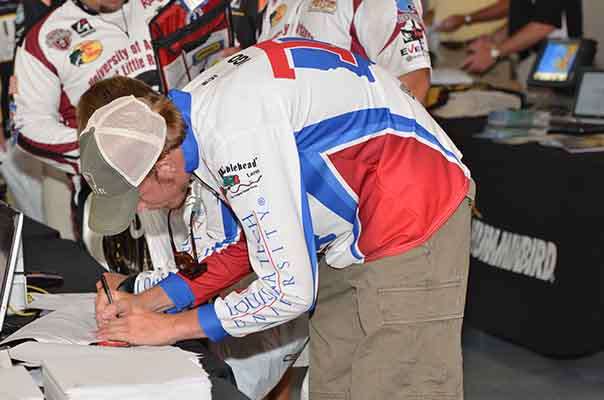 <p>
	Anglers sign registration forms to comply with Carhartt Bassmaster College Series rules.</p>
