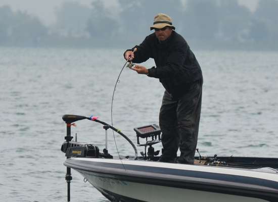 Scott Dobson fights a fish to the boat, as he applies pressure to the drag with his hand.