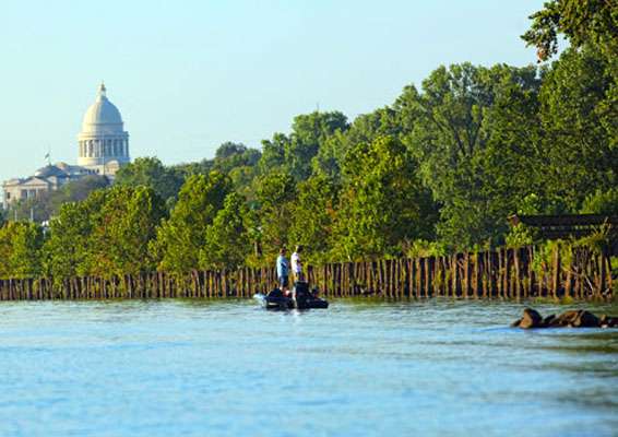 The Arkansas State Capitol Building looms over teams fishing near downtown Little Rock. 
