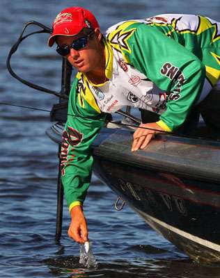 After breaking his line, Kyle Kirkland reaches into the water to retrieve his crankbait. 