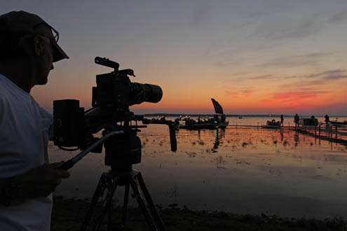 <p>
	Wes Miller with the camera crew shoots morning footage as the sunrise starts the beginning of Day Three at the Ramada Championship on Oneida Lake.</p>
