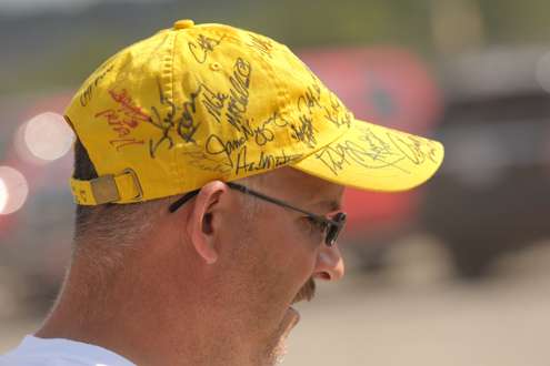 <p>
	A volunteer sports an autograph-adorned hat.</p>
