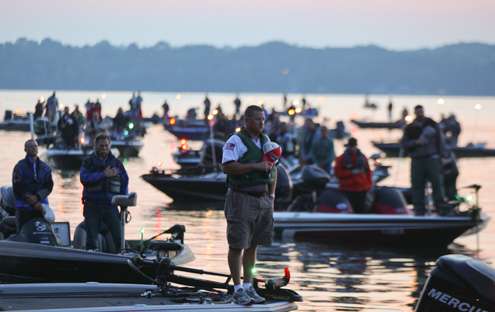 Competing anglers stand in their respective boats as the national anthem is played. 