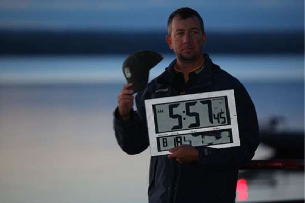 <p>
	B.A.S.S. worker Eric Nichols holds the time as anglers await the official start of Day Three.</p>
