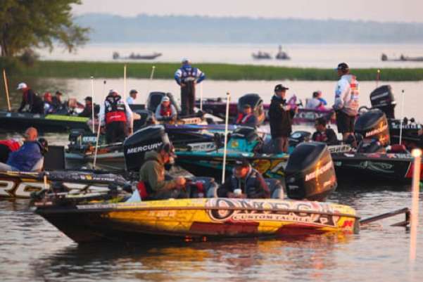 <p>
	Derek Remitz prepares his rods and reels while a sea of boats float behind him on Day Two.</p>
