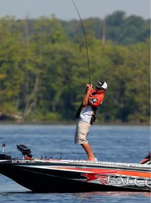 <p>
	Mike McClelland sets the hook on a fish in the grass. </p>
