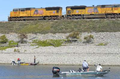 <p>
	A freight train speeds past Iaconelli as he fishes a riprap bank.</p>
