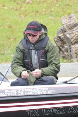 <p>Alex Goff, West Virginia, re-ties a lure while fishing Brush Creek on Wilson Lake.</p>
