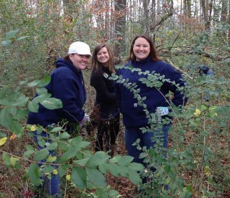 <p>Emily Hand, Helen Northcutt and Jennifer Dome stop for a pose behind tall privet plants.</p>

