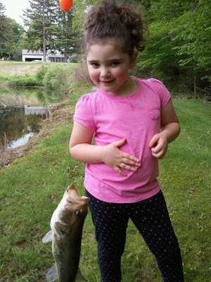 <p>
	She may not want to touch the bass, but this little one is still proud of her fish!</p>
