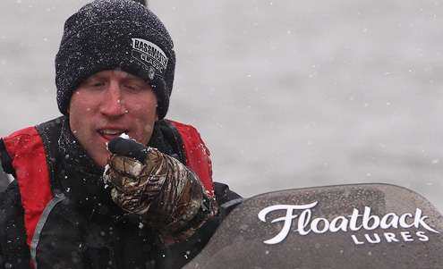 <p>Card takes a bite of the snow gathering on the windshield of his boat. </p>
