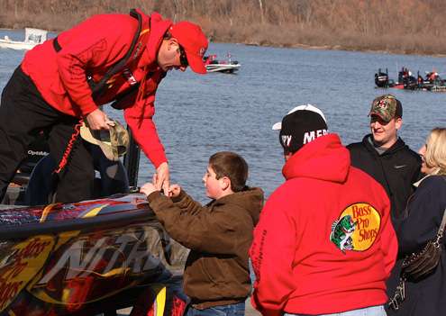 <p>Kevin VanDam tells his driver to stop so he can sign a cap for a young fishing fan.</p>
