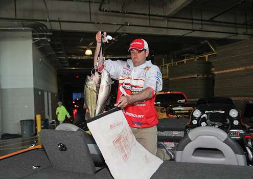 Casey Scanlon pulls his fish out of the livewell backstage before he weighs in.
