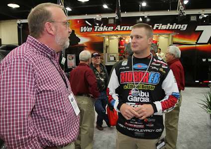 <p>Elite Series pro Bradley Roy chats with guests at the Triton booth.</p>
