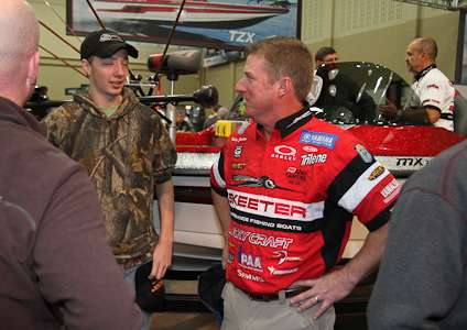 <p>Elite Series pro Kelly Jordon talks with a young fan in the Skeeter booth.</p>

