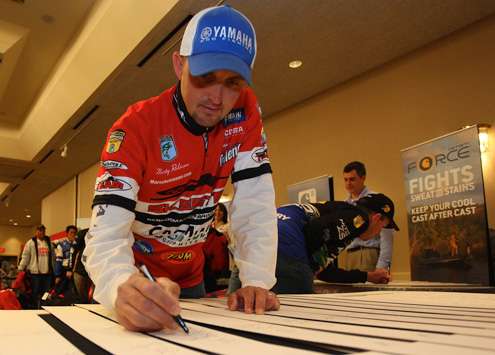 <p>Marty Robinson signs memorabilia to be used after the Classic.</p>
