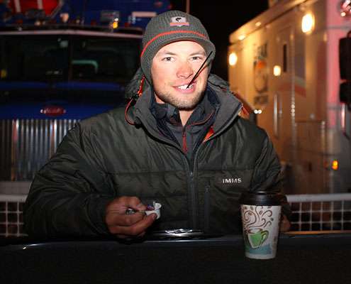 Brandon Palaniuk does his best to stay warm with some coffee on a morning that was in the 20s and felt colder.
