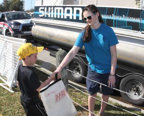 <p>A young volunteer hands off a fish at the Shimano Live Release boat.</p>
