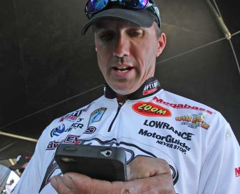 <p>Edwin Evers keeps tabs on the leaderboard on his smart phone, while he waits to weigh.</p>
