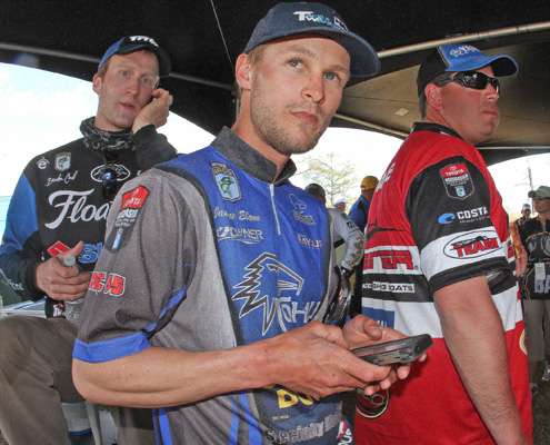<p>James Elam, a rookie on the Elite Series, watches the leaderboard on his smart phone.</p>
