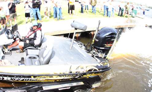 <p>With a stream of water washing behind, Bobby Lane pushes his boat on the trailer.</p>
