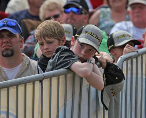 <p>A young fan rests against the fence waiting for an angler to hit the stage.</p>
