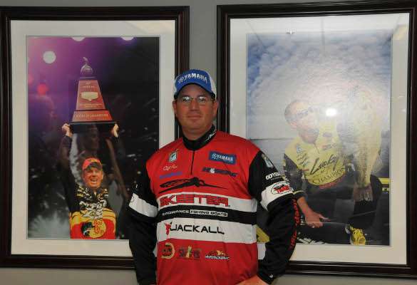 <p>Cliff Pace poses between photos of other Classic winners, Kevin VanDam and Skeet Reese. His photo will be added to the Classic champions' wall soon.</p>
