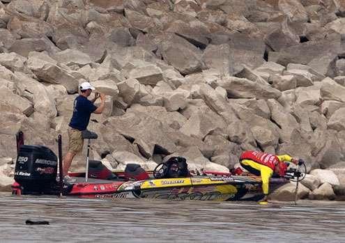 <p>Boyd Duckett reaches into the water for one of his best fish of the morning. </p>
