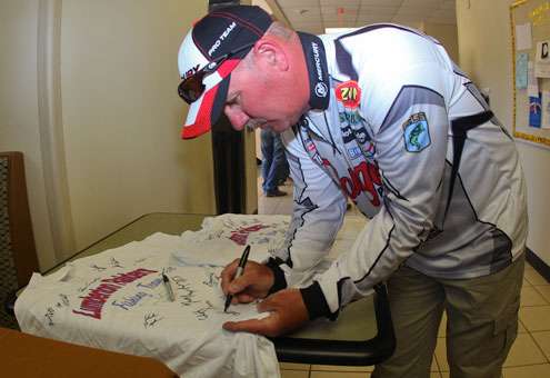 <p>Scott Rook stops to sign memorabilia before registration. </p>
